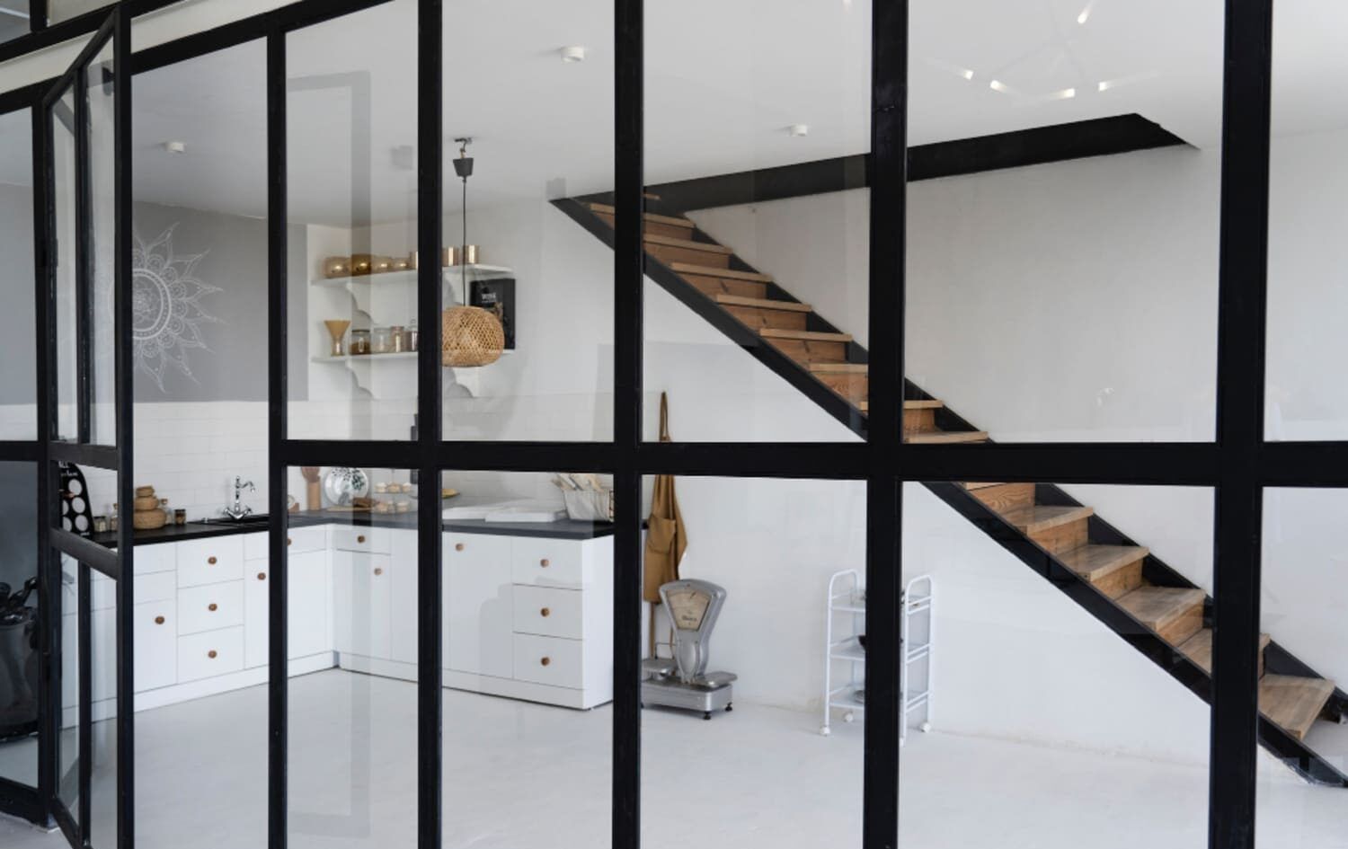 Galería interior cerrada con perfiles negros y cristal