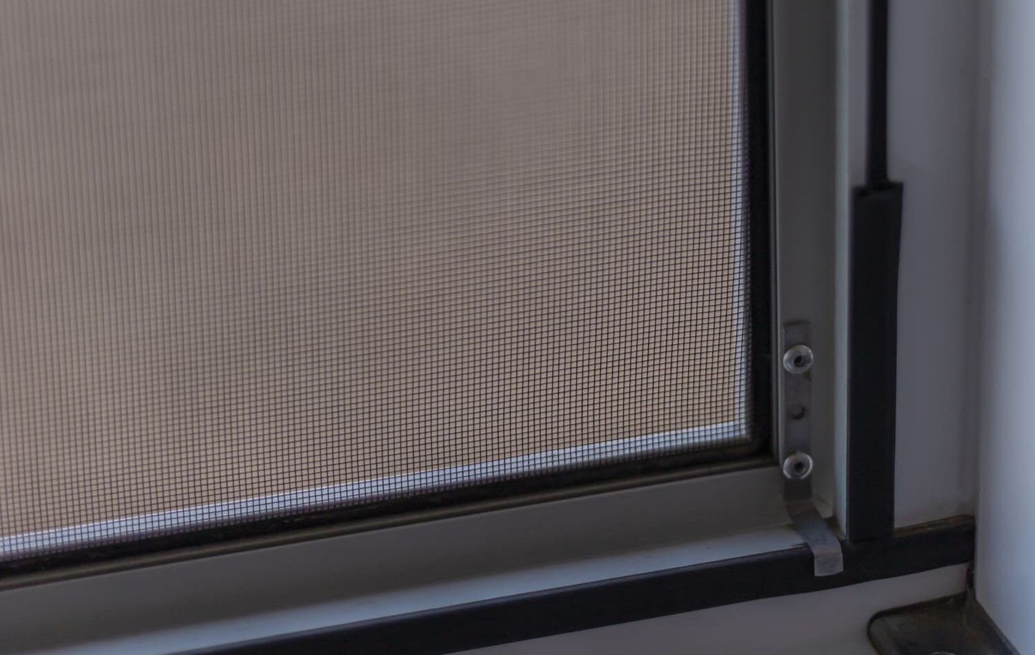 Detalle de una mosquitera montada en una ventana