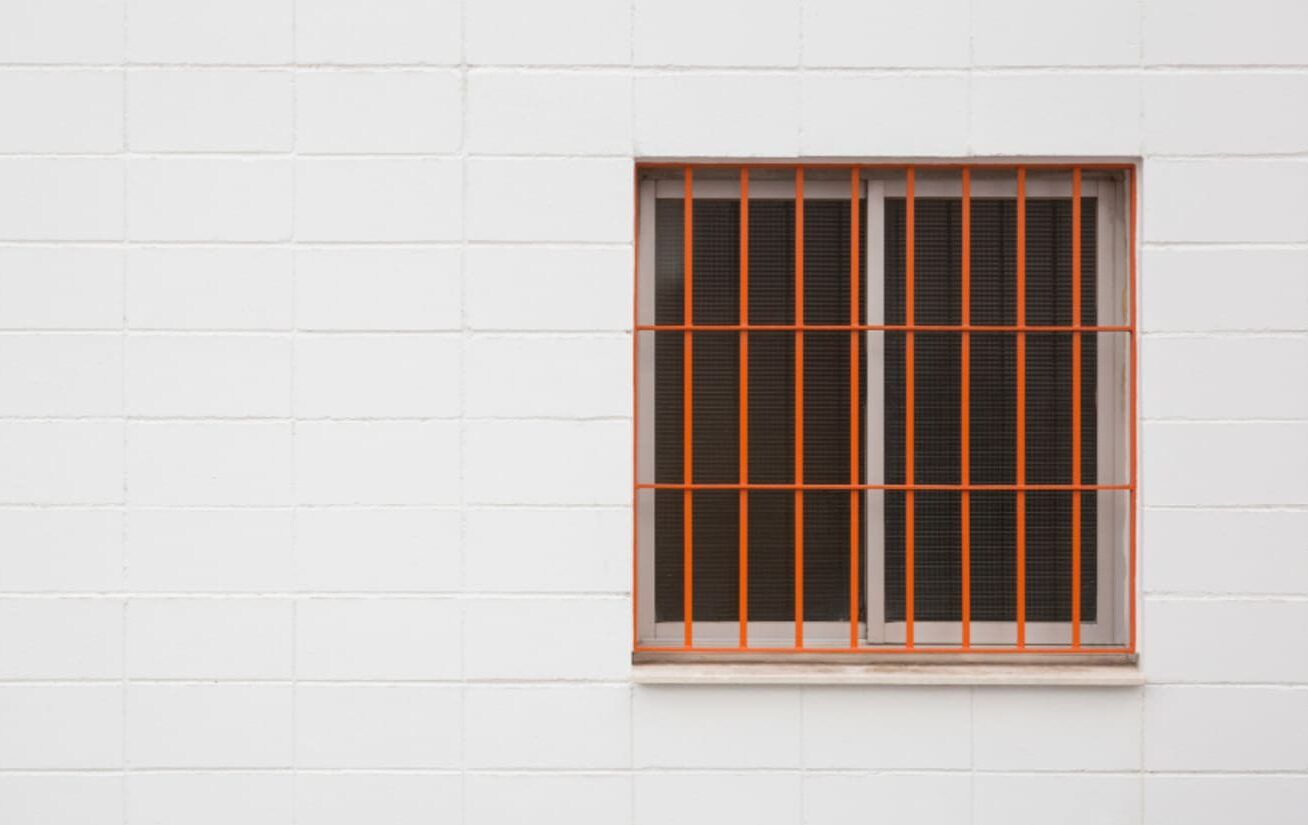 Reja de hierro en una ventana de fachada blanca